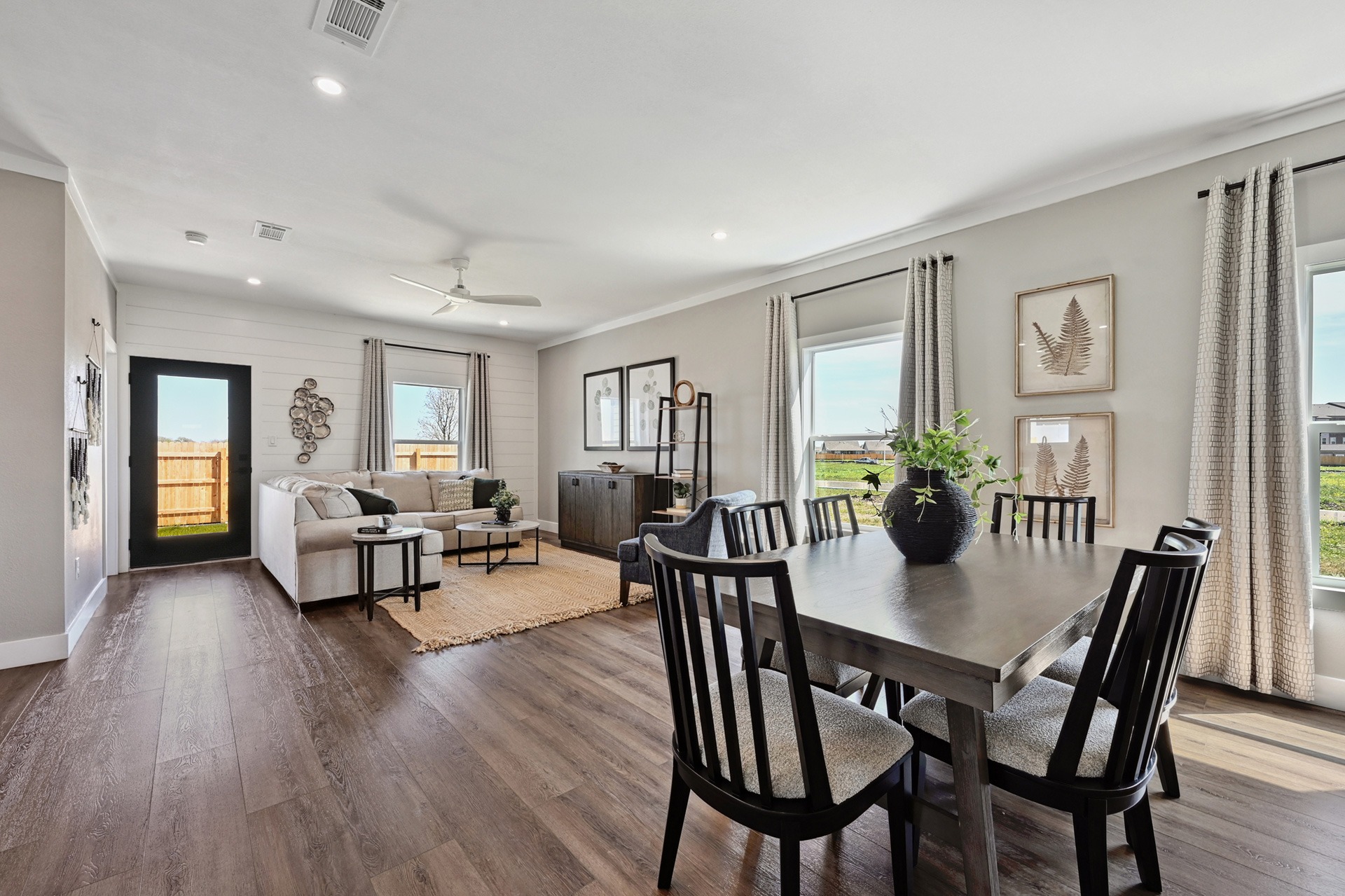 Great room living area at Verse Lockhart with large kitchen table and sofa sectional in view with modern accents and rugs.